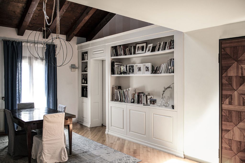 Foto della sala da pranzo con una libreria che diventa parete